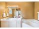 Bathroom featuring dual sinks, bright vanity lighting, and oversized bathtub at 5201 Lake Marion Golf Resort # 5201, Kissimmee, FL 34759