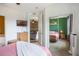View of bedroom with ceiling fan, green accent wall, and view to living room at 5201 Lake Marion Golf Resort # 5201, Kissimmee, FL 34759