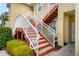 Close-up of condo building stairs, showcasing red stairs, white railings, and well-maintained landscaping at 5201 Lake Marion Golf Resort # 5201, Kissimmee, FL 34759