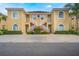 Attractive two-story condo with a yellow exterior, red tile roof, white stair railings, and well-maintained landscaping at 5201 Lake Marion Golf Resort # 5201, Kissimmee, FL 34759