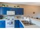 Bright kitchen with blue cabinets, white countertops, and stainless steel double sink at 5201 Lake Marion Golf Resort # 5201, Kissimmee, FL 34759