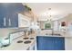 Kitchen with white countertops, blue cabinets, and view into living room at 5201 Lake Marion Golf Resort # 5201, Kissimmee, FL 34759