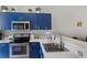 Bright kitchen featuring stainless steel appliances and blue cabinets at 5201 Lake Marion Golf Resort # 5201, Kissimmee, FL 34759