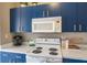 Kitchen featuring white countertops, blue cabinets, and white oven with microwave at 5201 Lake Marion Golf Resort # 5201, Kissimmee, FL 34759