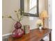Close-up of the entryway's decor, including a decorative mirror, table lamp, books, and stylish decorations at 7018 Arcadian Ct, Mount Dora, FL 32757