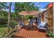 Inviting backyard deck with comfortable seating, umbrella, and lush landscaping offers a relaxing outdoor space at 1010 N Clayton St, Mount Dora, FL 32757