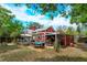 Expansive backyard with deck, patio, outdoor dining, and lush greenery for entertainment and relaxation at 1010 N Clayton St, Mount Dora, FL 32757