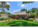 Charming two-story red home with a landscaped yard, quaint porch, and an American flag waving at 1010 N Clayton St, Mount Dora, FL 32757
