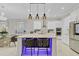 Modern kitchen island with bar seating, pendant lights, and views of the open living space at 10399 Macduff Dr, Orlando, FL 32832