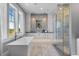 Spa-like bathroom with a sleek soaking tub, walk-in glass shower, and modern double vanity with large windows at 1224 Union Club Dr, Winter Garden, FL 34787
