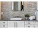 Close-up of the modern bathroom vanity with a wall-mounted faucet, gray backsplash, and gray countertops at 1224 Union Club Dr, Winter Garden, FL 34787