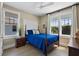 Bright bedroom with a four poster bed, wood flooring, and natural light from two large windows at 1224 Union Club Dr, Winter Garden, FL 34787