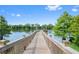 Scenic view of a wooden pier extending into a serene lake, surrounded by lush greenery under a clear blue sky at 1224 Union Club Dr, Winter Garden, FL 34787