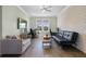 Living room with a large window, brick accent wall, hard wood floors, and stylish contemporary furnishings at 1224 Union Club Dr, Winter Garden, FL 34787