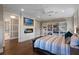 A bright main bedroom featuring a fireplace, built-in shelving, hardwood floors, and a ceiling fan at 1224 Union Club Dr, Winter Garden, FL 34787