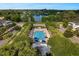 Community pool featuring palm trees, shaded umbrellas, lounge seating, and serene lake views at 1224 Union Club Dr, Winter Garden, FL 34787