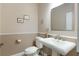 Neutral half bath boasts pedestal sink, decorative framed art, and clean white toilet at 12706 S Lake Sawyer Ln, Windermere, FL 34786
