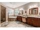 Serene bathroom featuring dual sinks, a soaking tub, and neutral tones creating a spa-like atmosphere at 12706 S Lake Sawyer Ln, Windermere, FL 34786