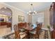 Formal dining room featuring a chandelier, wooden table, and an arched doorway leading to the living space at 12706 S Lake Sawyer Ln, Windermere, FL 34786