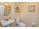 Cozy half-bathroom featuring a pedestal sink, toilet, decorative wall art, and neutral wall tones at 487 Oak Haven Dr # 487, Altamonte Springs, FL 32701
