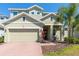 Charming two-story home with a well-manicured front yard, brick walkway, and a two-car garage at 609 Fortuna Dr, Davenport, FL 33837
