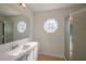 Bright bathroom featuring a modern vanity, unique octagonal window, and a glass-enclosed shower for a clean, contemporary feel at 104 Birmingham Dr, Kissimmee, FL 34758