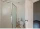 Bright bathroom featuring a stand-up shower, toilet and door leading into another room at 104 Birmingham Dr, Kissimmee, FL 34758