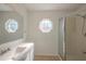 Well-lit bathroom with a wide mirror, modern vanity, walk-in shower, and unique octagonal window at 104 Birmingham Dr, Kissimmee, FL 34758