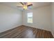 Bright bedroom with ceiling fan, and light-colored walls complemented by wood-look laminate flooring and a large window at 104 Birmingham Dr, Kissimmee, FL 34758