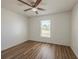 Bright bedroom features wood-look floors, a ceiling fan, and window, offering a serene retreat at 104 Birmingham Dr, Kissimmee, FL 34758