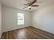Bright bedroom with ceiling fan, and light-colored walls complemented by wood-look laminate flooring and a large window at 104 Birmingham Dr, Kissimmee, FL 34758