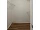 Spacious walk-in closet with wood-look floors and ample shelving for organized storage at 104 Birmingham Dr, Kissimmee, FL 34758