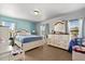 Light-filled bedroom with light blue accent wall, plush carpet, and natural light at 10820 Wyandotte Dr, Clermont, FL 34711