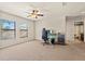 Spacious bedroom with carpet, ceiling fan, two windows, and a gaming setup at 10820 Wyandotte Dr, Clermont, FL 34711