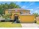 Inviting two-story home featuring a well-manicured lawn and an attached two-car garage at 10820 Wyandotte Dr, Clermont, FL 34711