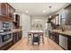 Spacious kitchen features an island, stainless steel appliances, granite countertops and dark wood cabinets at 10820 Wyandotte Dr, Clermont, FL 34711