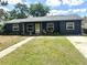 Inviting single-story house featuring dark siding, a cozy porch with seating, and a green front lawn at 1098 Henry Balch Dr, Orlando, FL 32810