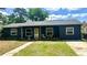 Charming single-story home with a dark exterior, welcoming front porch, and well-maintained lawn at 1098 Henry Balch Dr, Orlando, FL 32810