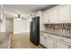 Open kitchen featuring white cabinets, granite counters, stainless steel appliances, and wood-look floors at 1109 Beatrice Dr, Orlando, FL 32810