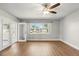 Bright living room features ceiling fan, wood-look floors, a large window and french doors to an enclosed patio at 1109 Beatrice Dr, Orlando, FL 32810