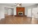 Spacious living room with fireplace, ceiling fan, wood-look floors, and french doors to an enclosed patio at 1109 Beatrice Dr, Orlando, FL 32810