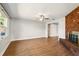 Living room with wood-look floors, a brick fireplace, ceiling fan, and lots of natural light at 1109 Beatrice Dr, Orlando, FL 32810