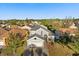 Aerial view of a gray two-story home with manicured landscaping and mature trees at 12557 Crayford Ave, Orlando, FL 32837