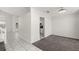 Inviting interior design of carpeted living room offering kitchen view with white cabinets and granite counters at 12557 Crayford Ave, Orlando, FL 32837