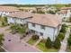 Aerial view of two-story homes with tile roofs, paver driveways, and green lawns at 1312 Shinnecock Hills Dr, Davenport, FL 33896