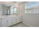 Bright bathroom featuring double sinks with white cabinets, quartz countertops and a large mirror at 1312 Shinnecock Hills Dr, Davenport, FL 33896