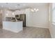 Modern kitchen with white cabinets, stainless steel appliances, a center island, and wood-look tile flooring at 1312 Shinnecock Hills Dr, Davenport, FL 33896