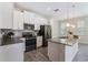 Updated kitchen with gray countertops, stainless appliances, and white cabinets with recessed lighting throughout at 1312 Shinnecock Hills Dr, Davenport, FL 33896