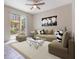 Open concept living room with a large couch, modern decor, and sliding doors to the backyard at 1312 Shinnecock Hills Dr, Davenport, FL 33896