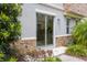 Outdoor view of a sliding glass door, stone accents, and well-manicured landscaping at 1312 Shinnecock Hills Dr, Davenport, FL 33896